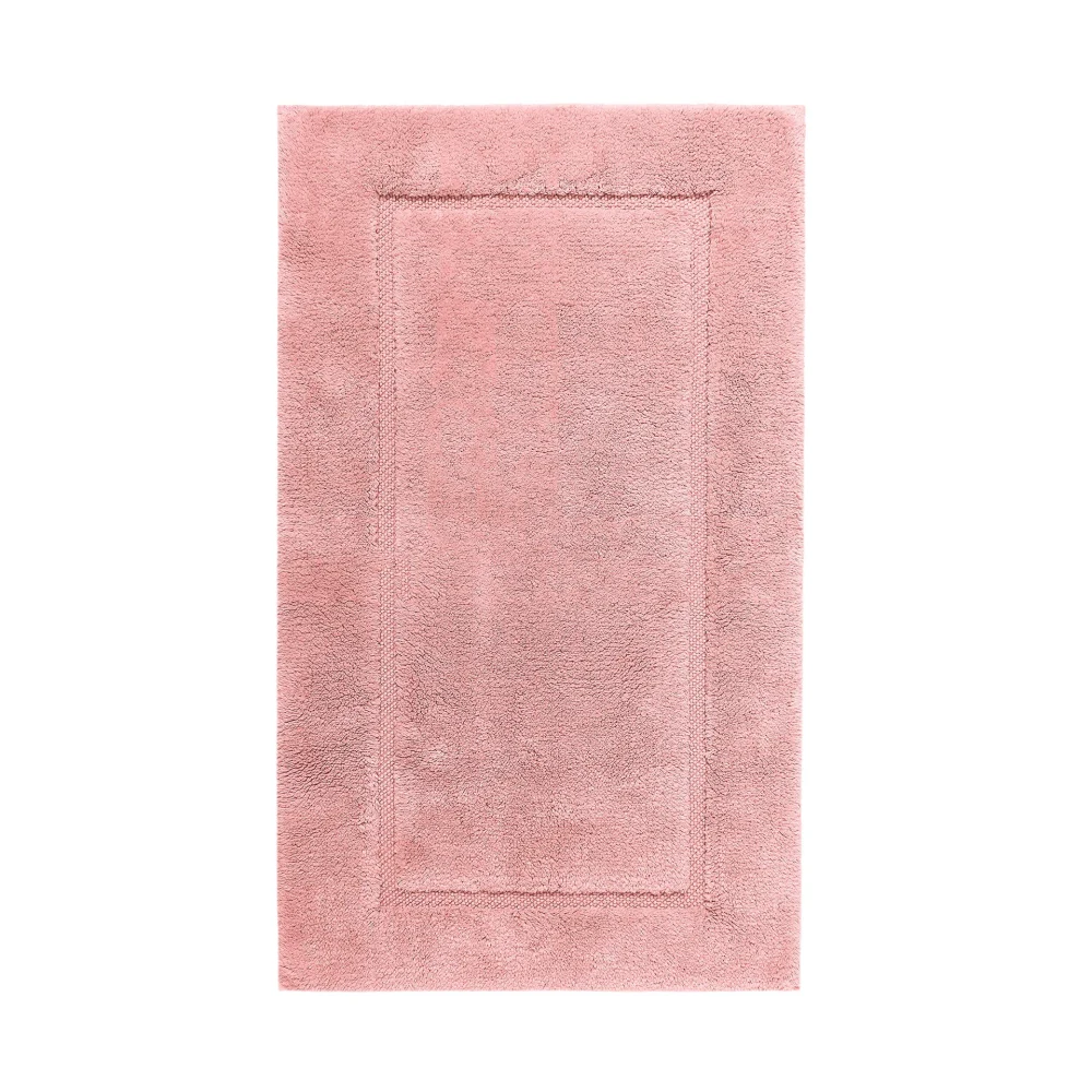 Ovanifrån-vy av en utsträckt Egoist badrumsmatta i färgtonen Blush (Puderrosa). Detaljerat studiophoto som framhäver den mjuka strukturen hos den exklusiva GIZA-bomullen.