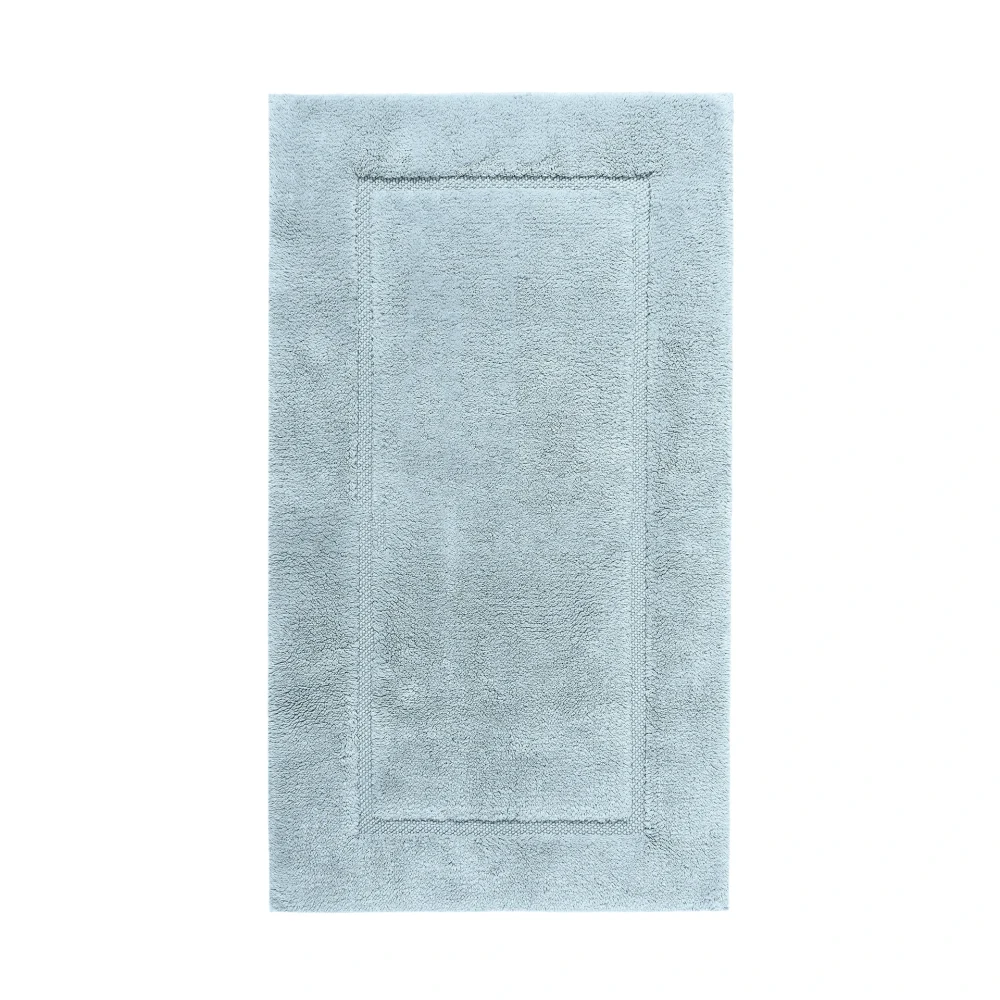 Högkvalitativt produktfoto sett ovanifrån på en Graccioza Egoist badrumsmatta i färgen Sea Mist (Ljusturkos). Bilden fångar den tunga, högabsorberande luggen och den lyxiga finishen.