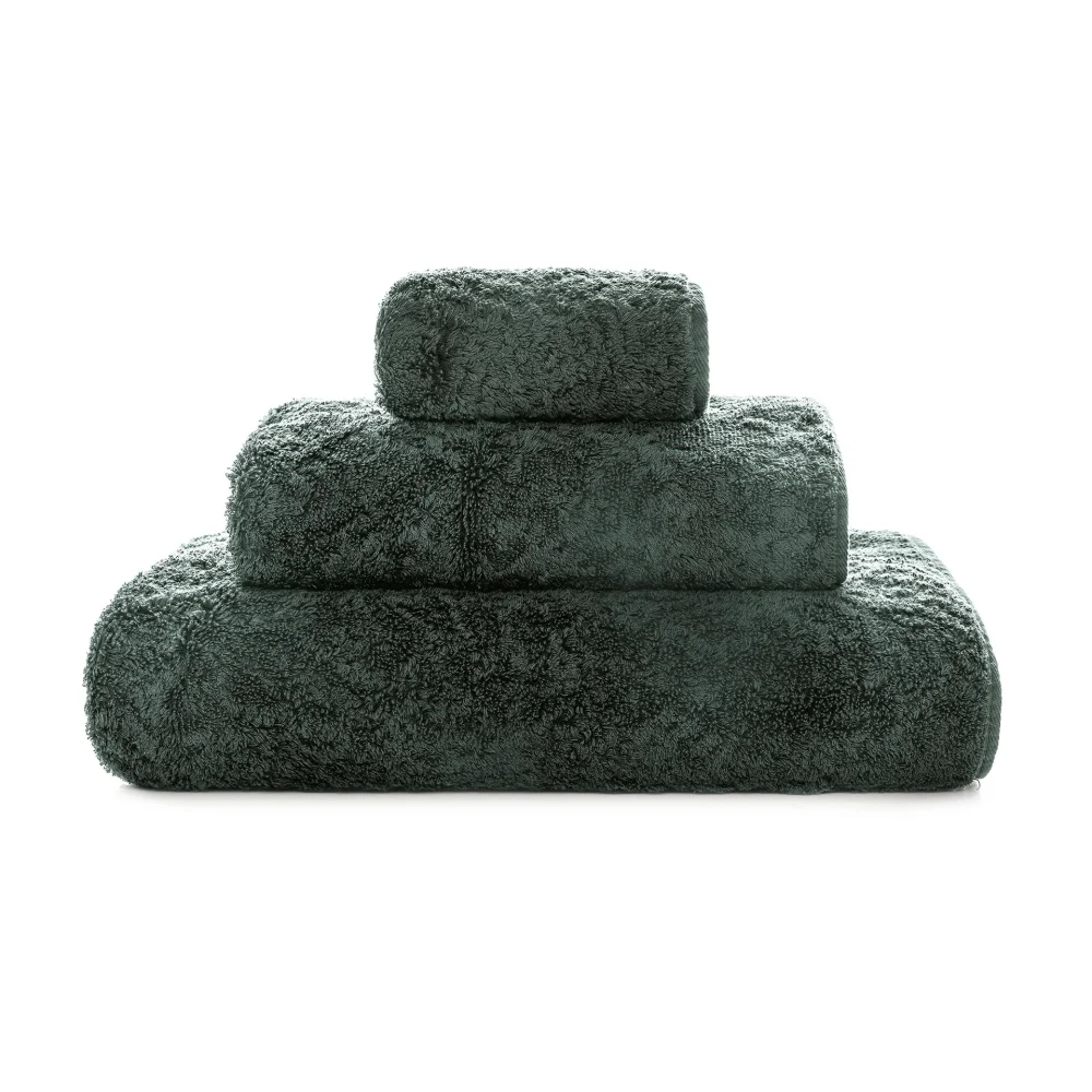 Lyxiga, staplade frottéhanddukar Graccioza Egoist i den eleganta färgnyansen Moss (Mörk djup grön) sett framifrån.