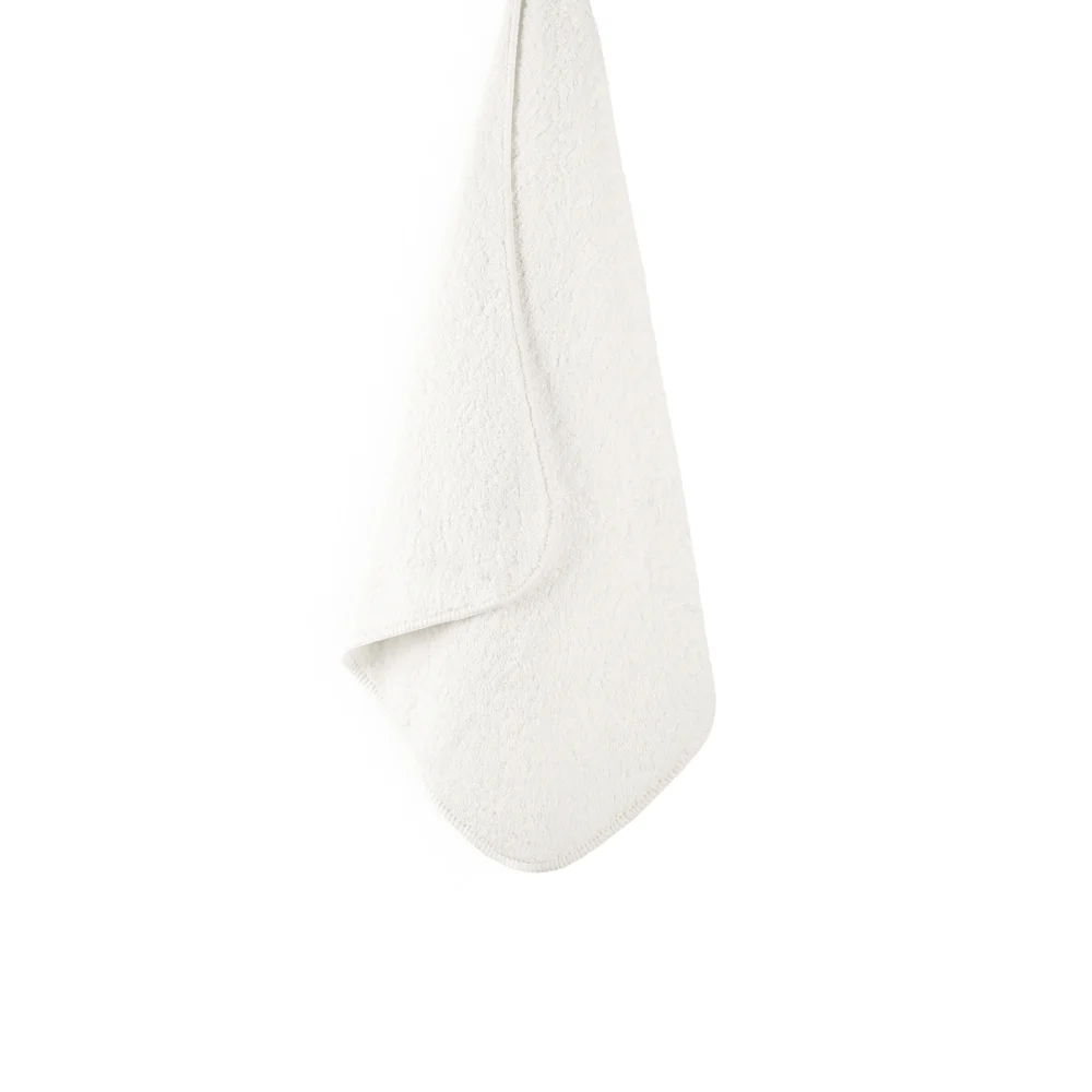 En stor, mjuk och upphängd badhandduk Graccioza Heritage i den eleganta nyansen Snow som visar handdukens vackra fall.